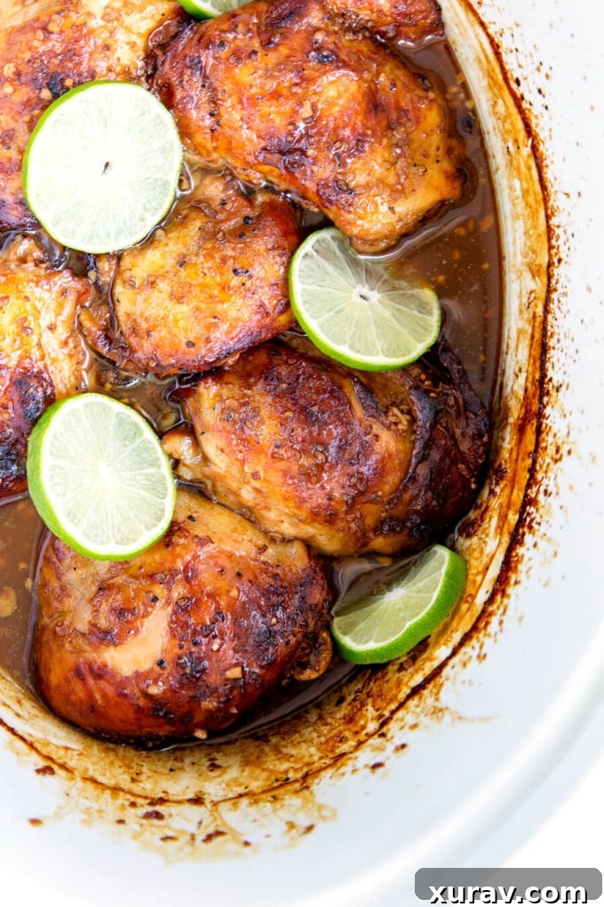 Crockpot Garlic Lime Chicken in marinade with fresh lime slices.