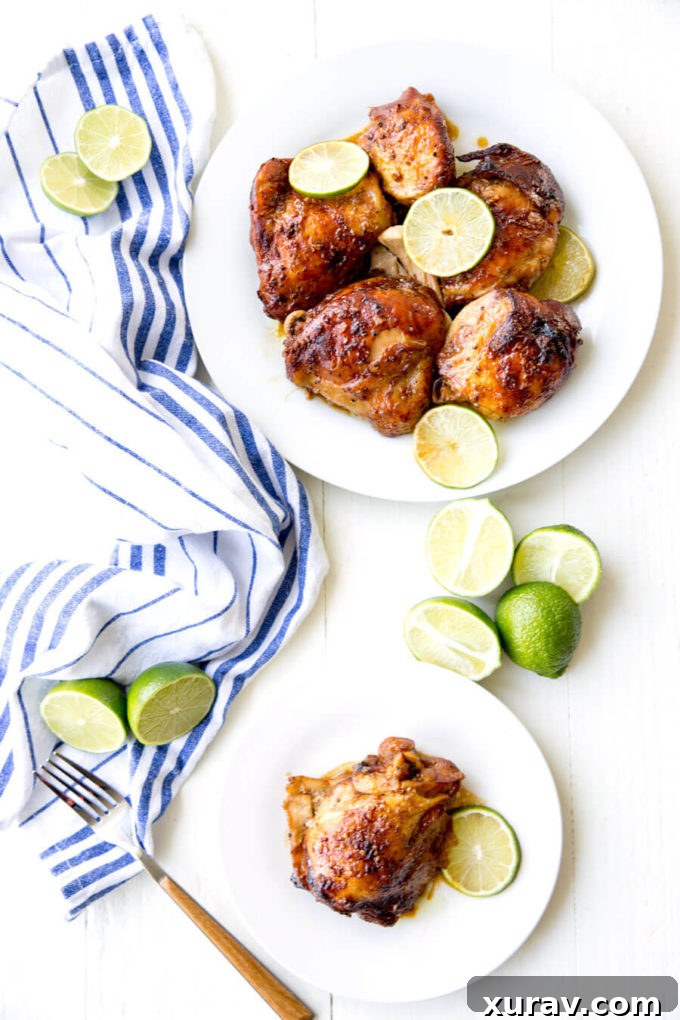 Crockpot Garlic Lime Chicken on white plate, garnished with fresh lime slices.