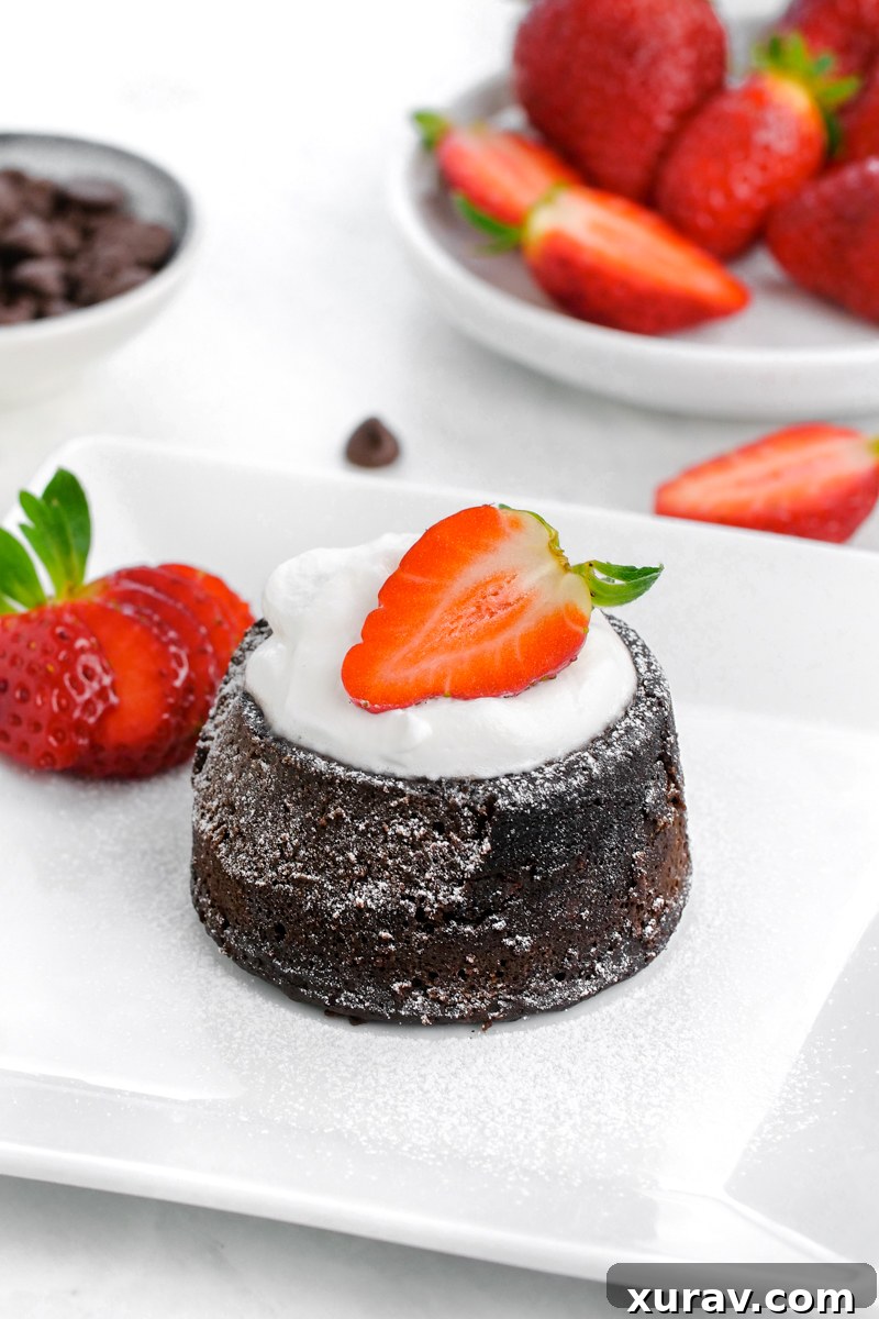 An exquisite Instant Pot Chocolate lava cake, elegantly topped with a single fresh strawberry, highlighting its rich brown hue.