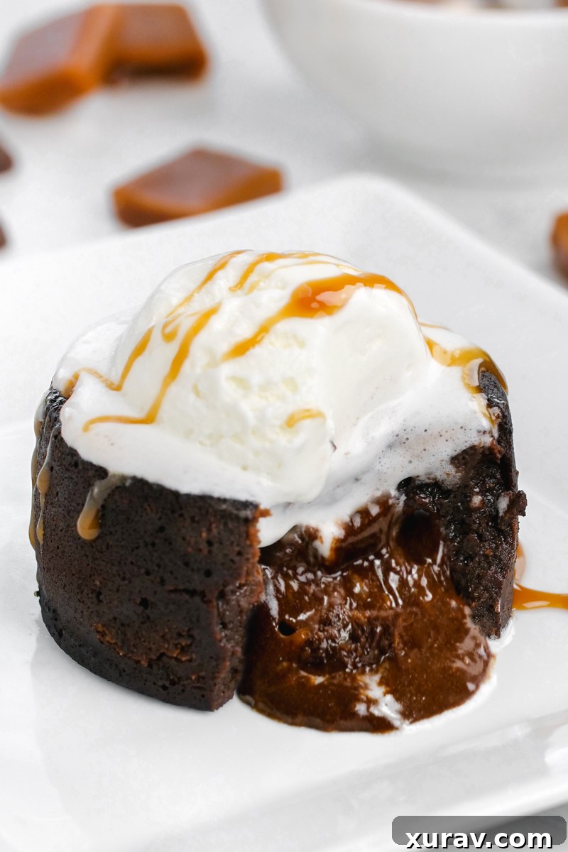 An enticing caramel-filled Instant Pot lava cake, showcasing its gooey center, served on a white plate and topped with a scoop of creamy ice cream.