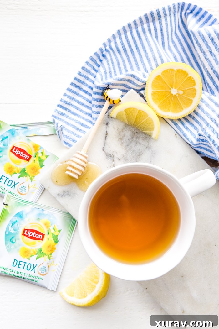 A mug of detox tea, top down shot with packaging, lemon, and honey