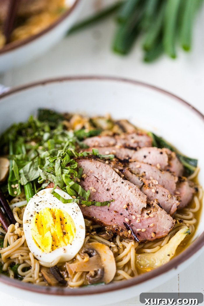 A bowl of grilled pork ramen with egg and vegetables