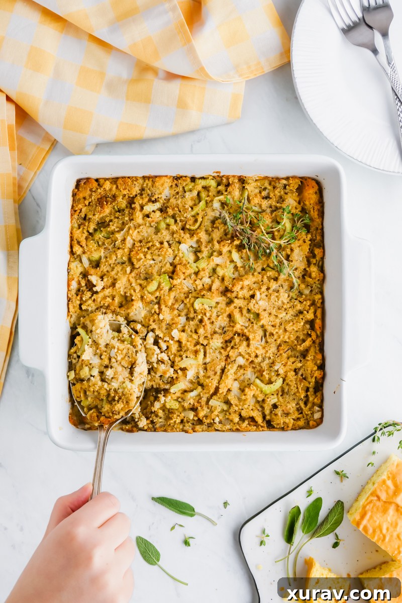 A golden-brown cornbread casserole, fresh out of the oven, steaming gently in a ceramic dish.