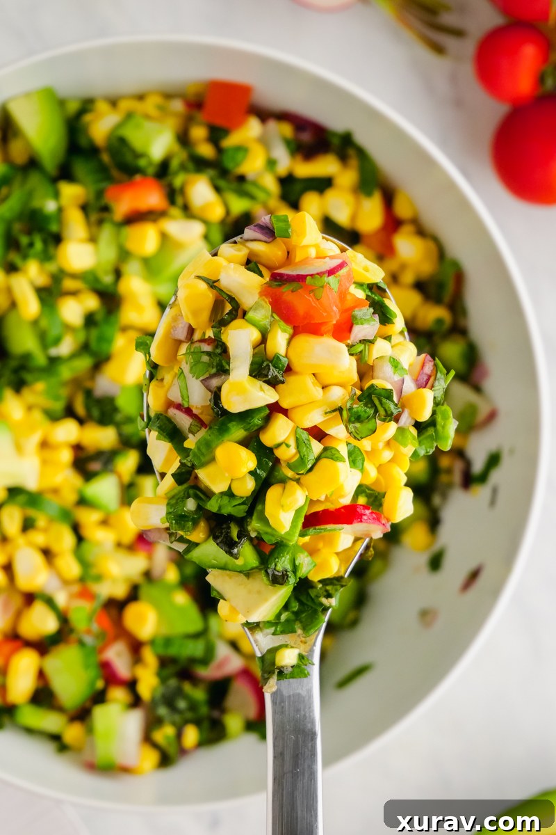 Fresh Corn Salad in a white bowl with colorful vegetables