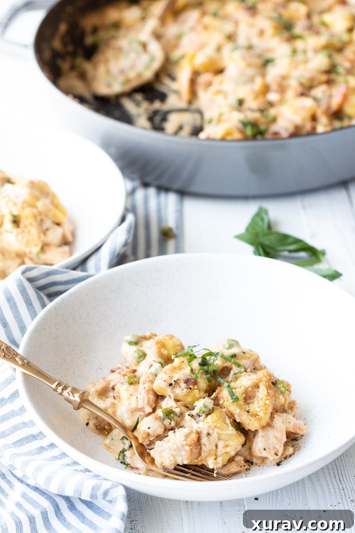 The finished pork and tortellini skillet bake, ready to be served, garnished with fresh basil.