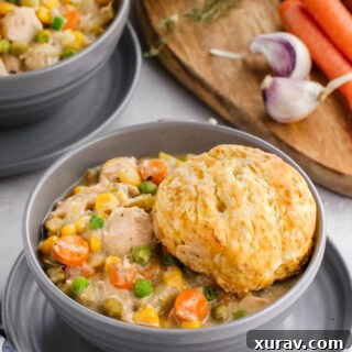 Close-up of a serving of slow cooker chicken pot pie with a golden biscuit.