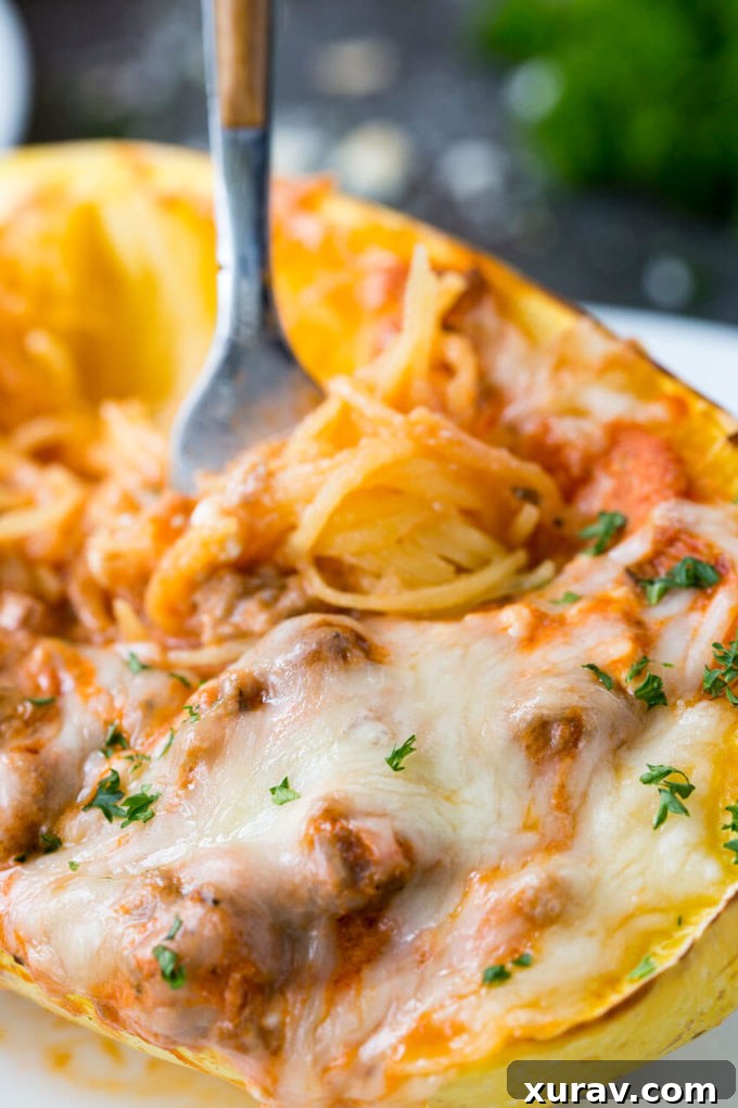 Two halves of baked spaghetti squash filled with rich lasagna mixture and melted cheese, ready to serve.