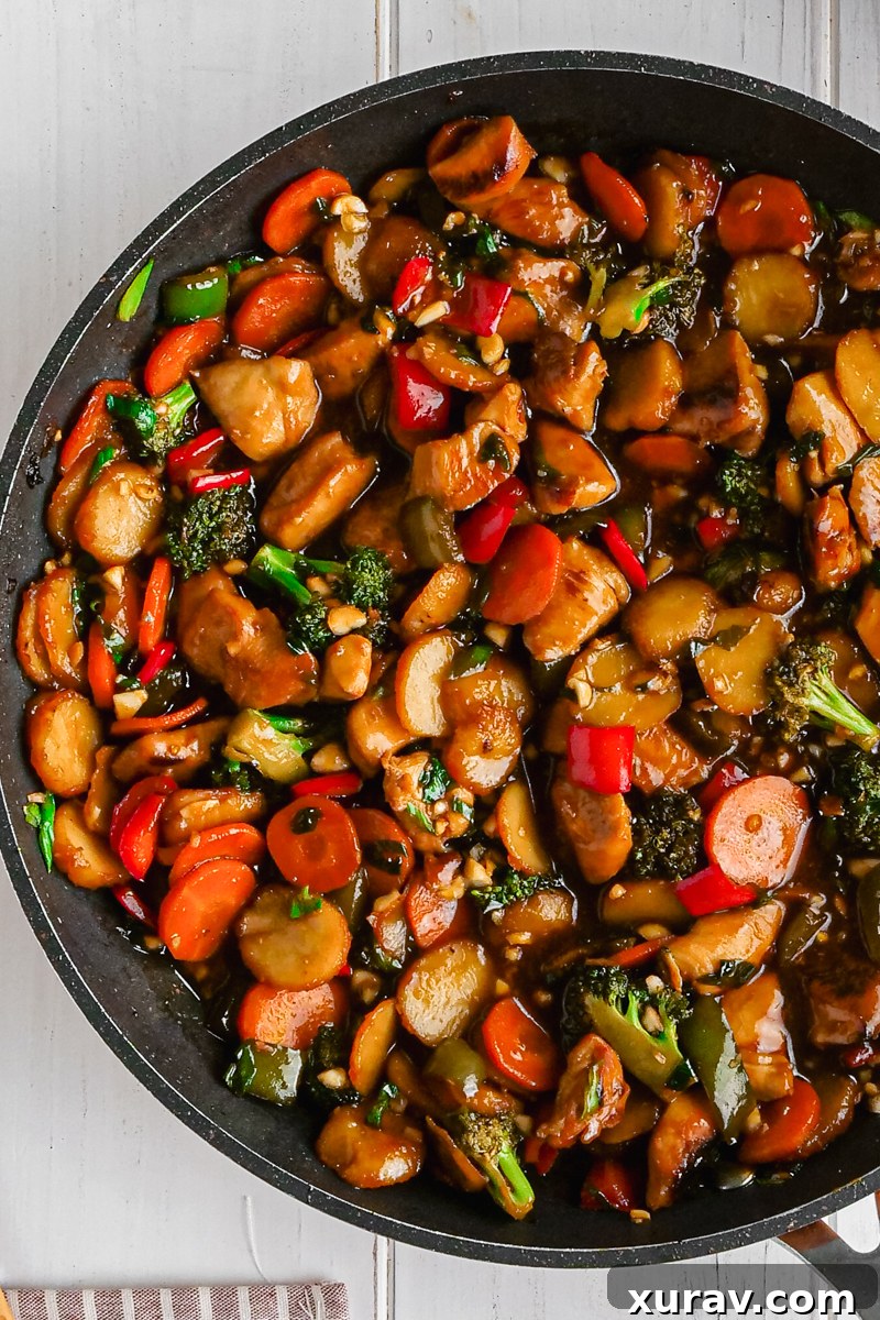 Delicious Kung Pao Chicken served with rice, garnished with green onions and peanuts.