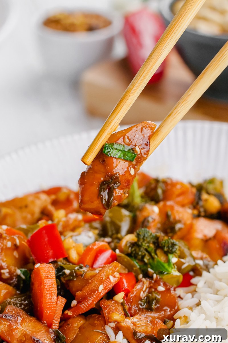 Close-up of Kung Pao Chicken in a wok, showing the colorful vegetables and tender chicken.