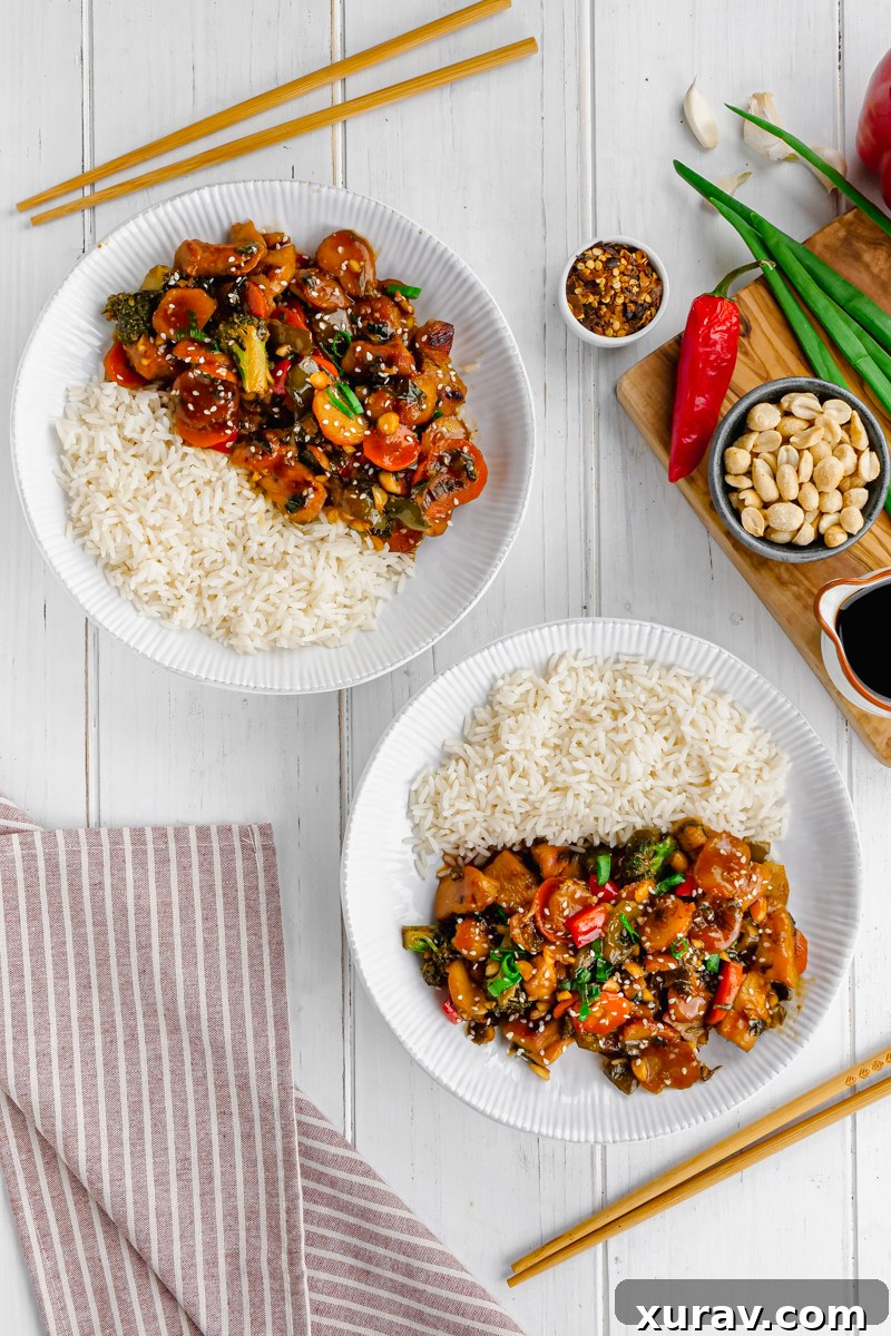 Kung Pao Chicken in a bowl with chopsticks, ready to be eaten.