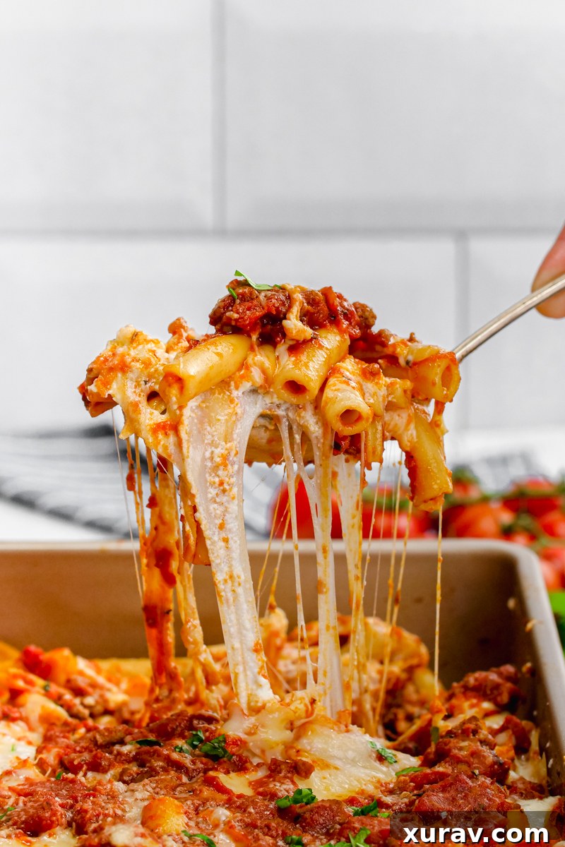 Close-up of baked ziti with melted cheese, showing rich sauce and pasta texture.