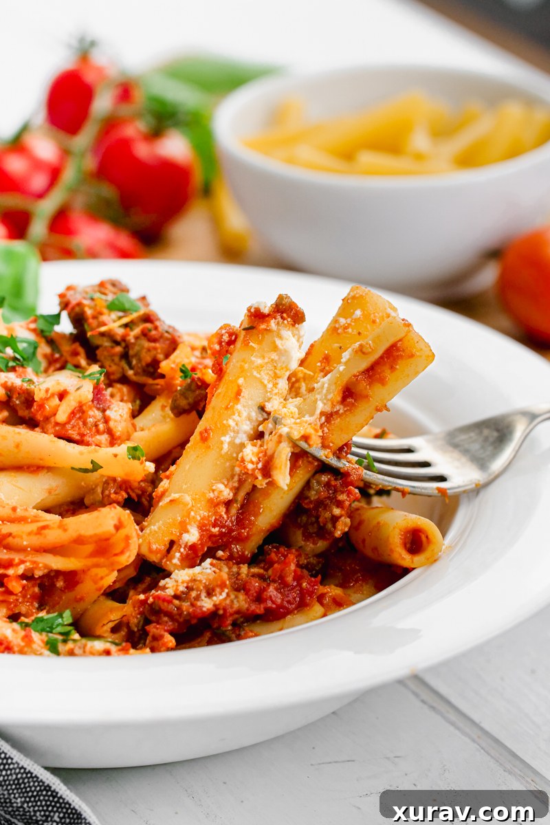 A large serving of freshly baked ziti, still bubbling and hot from the oven, ready to be enjoyed.