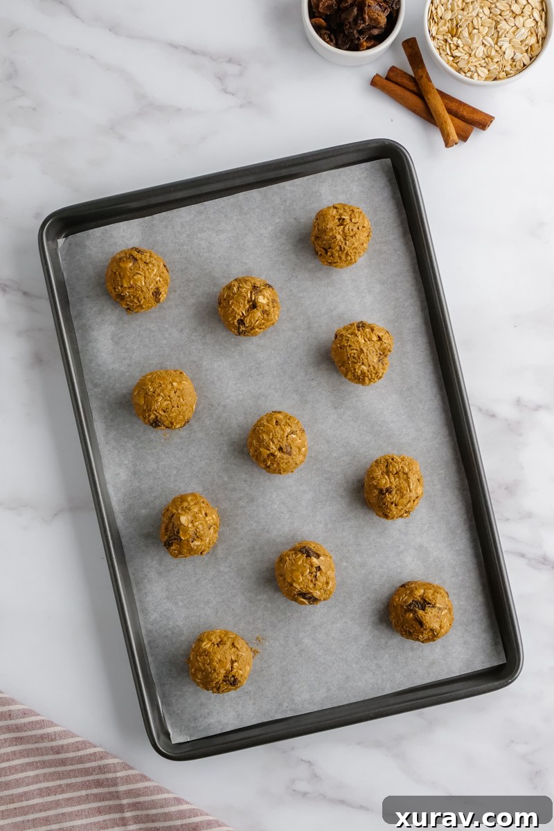 Oatmeal raisin cookie dough scooped onto a baking sheet, ready for the oven