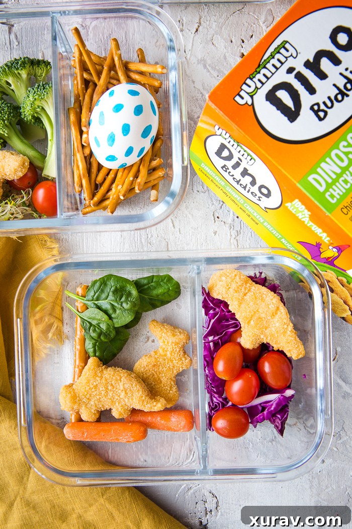 A child holding a bento box with Yummy Dino Buddies and fresh fruit.