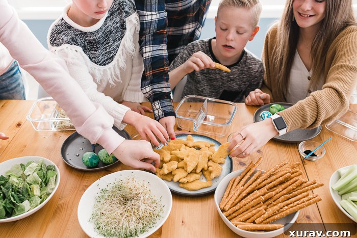 Two kids bento boxes filled with Yummy Dino Buddies, fruits, and vegetables, arranged to look like a prehistoric scene.