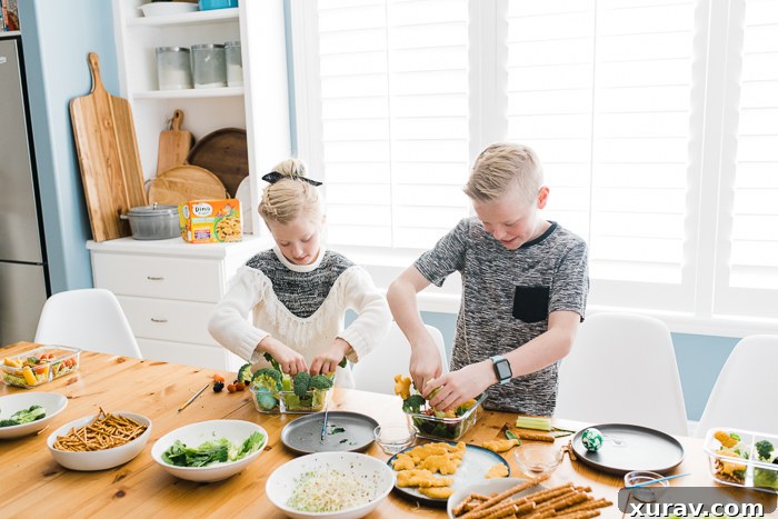 A colorful bento box with Yummy Dino Buddies, pretzel sticks, and grape tomatoes.