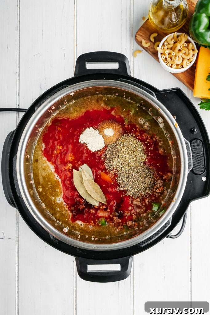 The Instant Pot now contains the beginnings of American Goulash: browned beef, sautéed aromatics, and all the sauce ingredients, stirred and ready for pasta.