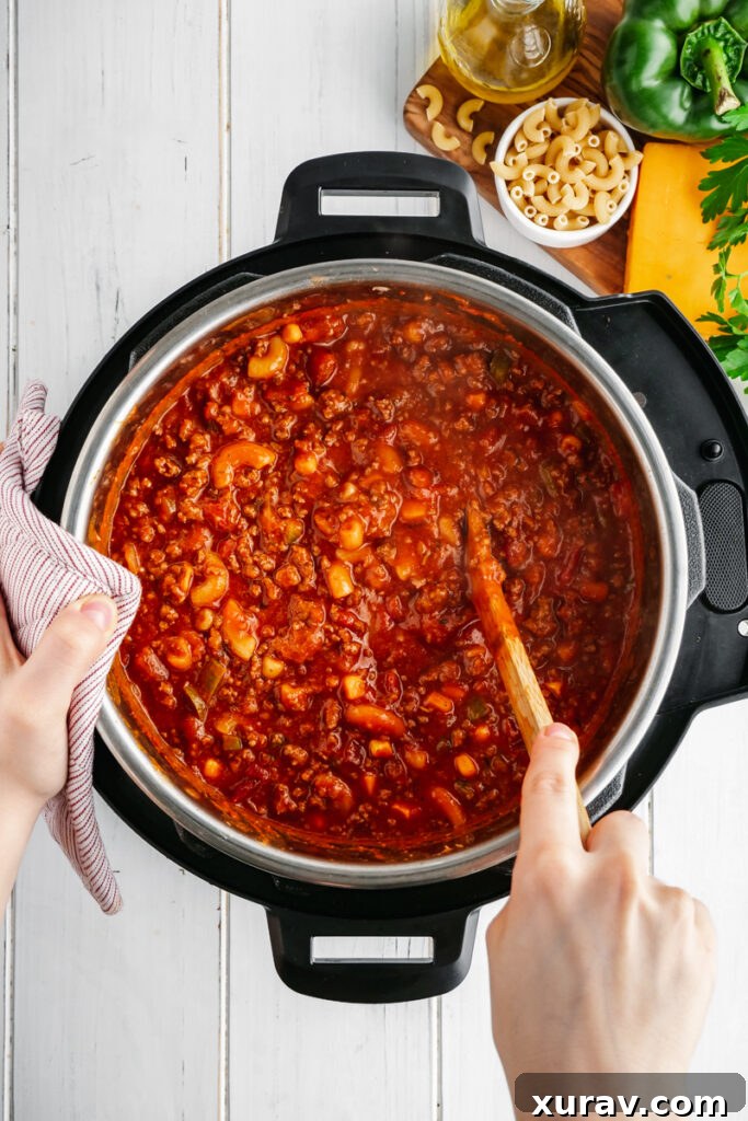 A close-up shot of the Instant Pot containing freshly cooked elbow macaroni in a vibrant tomato sauce, ready to be served as American Goulash.