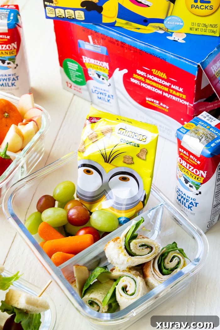 A bento style box, with sandwich sushi and other lunch fixings.