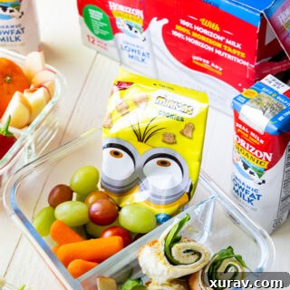 A bento style box, with sandwich sushi and other lunch fixings.