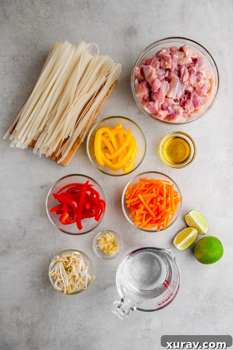 Fresh ingredients laid out for Instant Pot Pad Thai, including chicken, rice noodles, vegetables, and sauce components