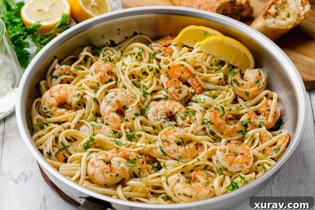 A large skillet filled with perfectly cooked Shrimp Scampi and linguine, garnished with fresh parsley.