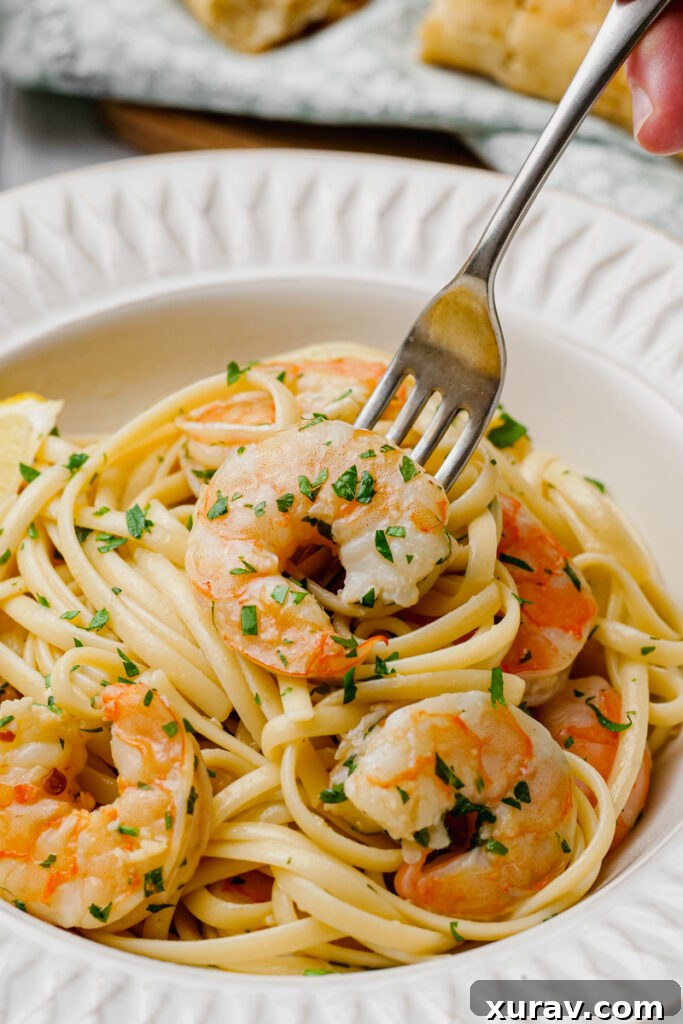 Linguine and shrimp scampi elegantly twisted around a fork, ready for a bite.