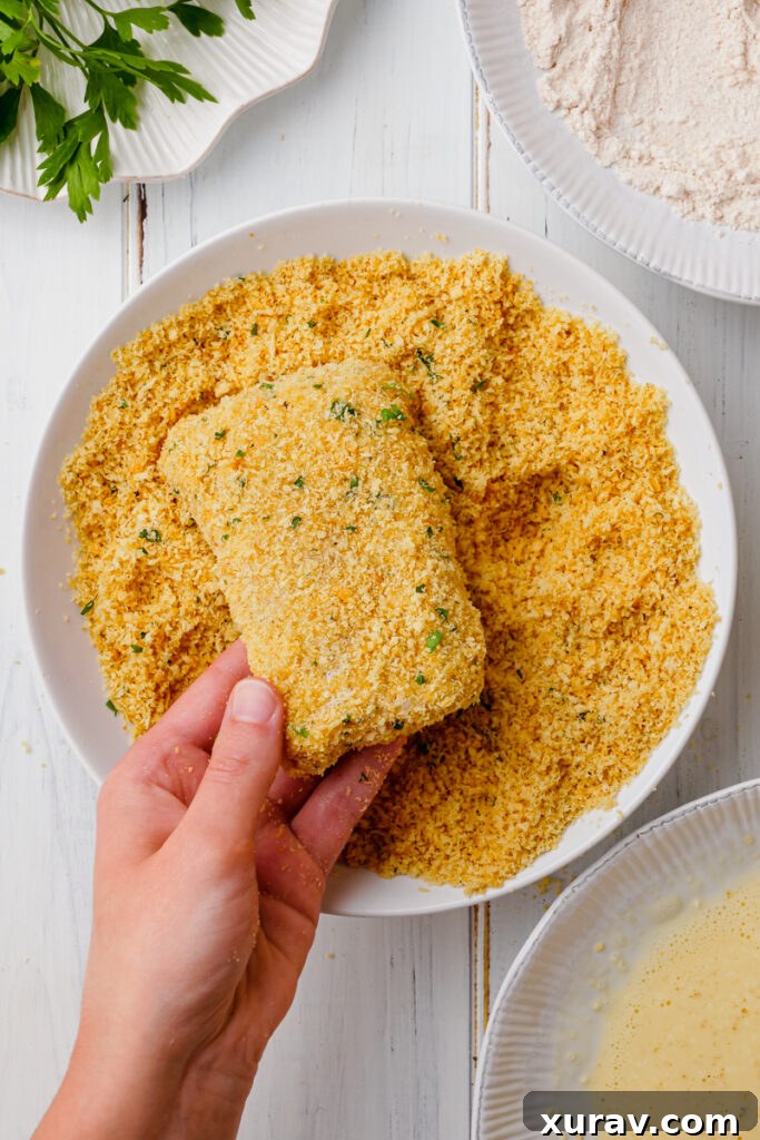 Dredging fish and coating in a crispy coating for an oven fried fish