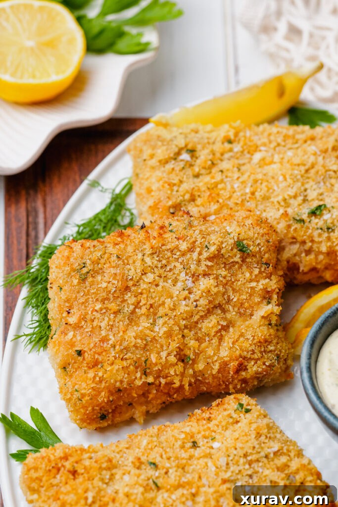 Oven fried fish on a white plate with garnish, ready to serve