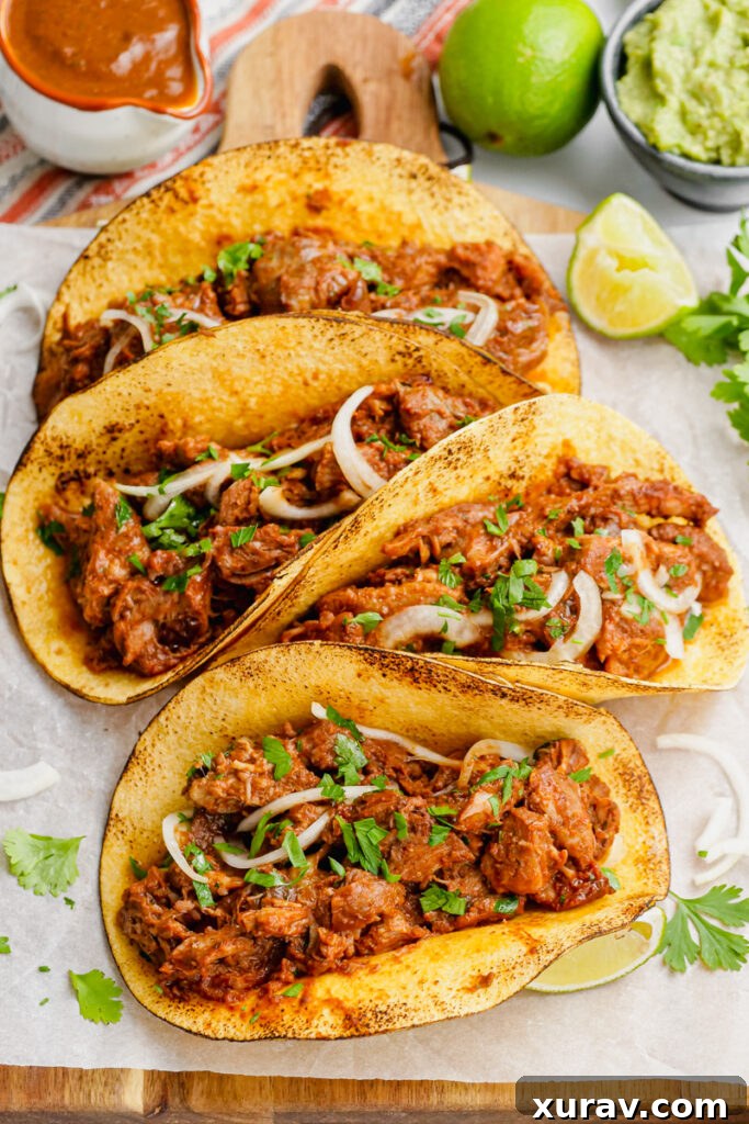 Pork mole tacos, served with a variety of fresh condiments including cilantro and lime.