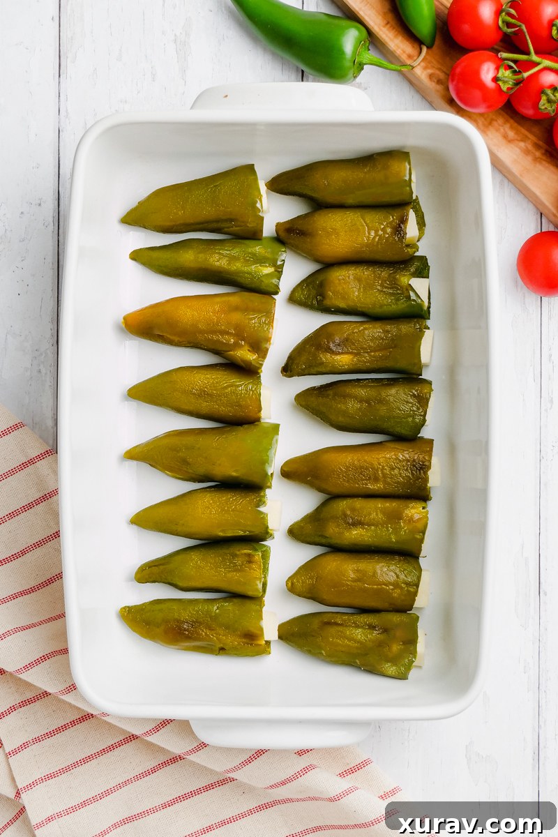 Baked chiles rellenos stuffed with cheese on a greased baking sheet