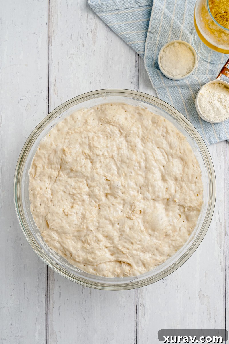 beer bread sitting out inn a glass bowl with ingredients to the side of the bowl
