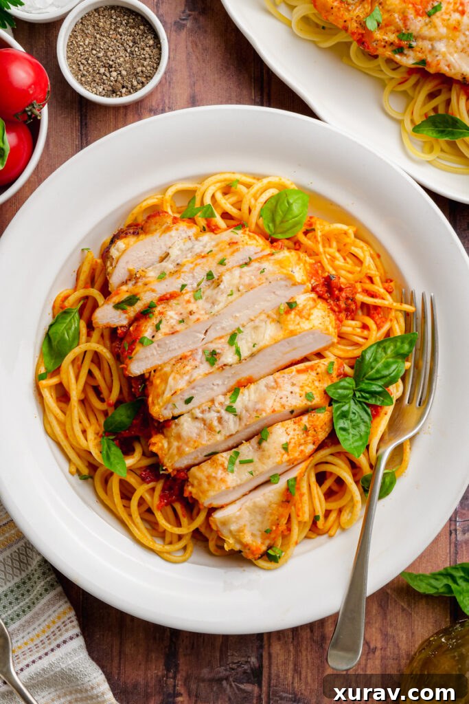 Slow Cooker Chicken Pomodoro served on a white plate with a fork, ready to be enjoyed, garnished with fresh basil.