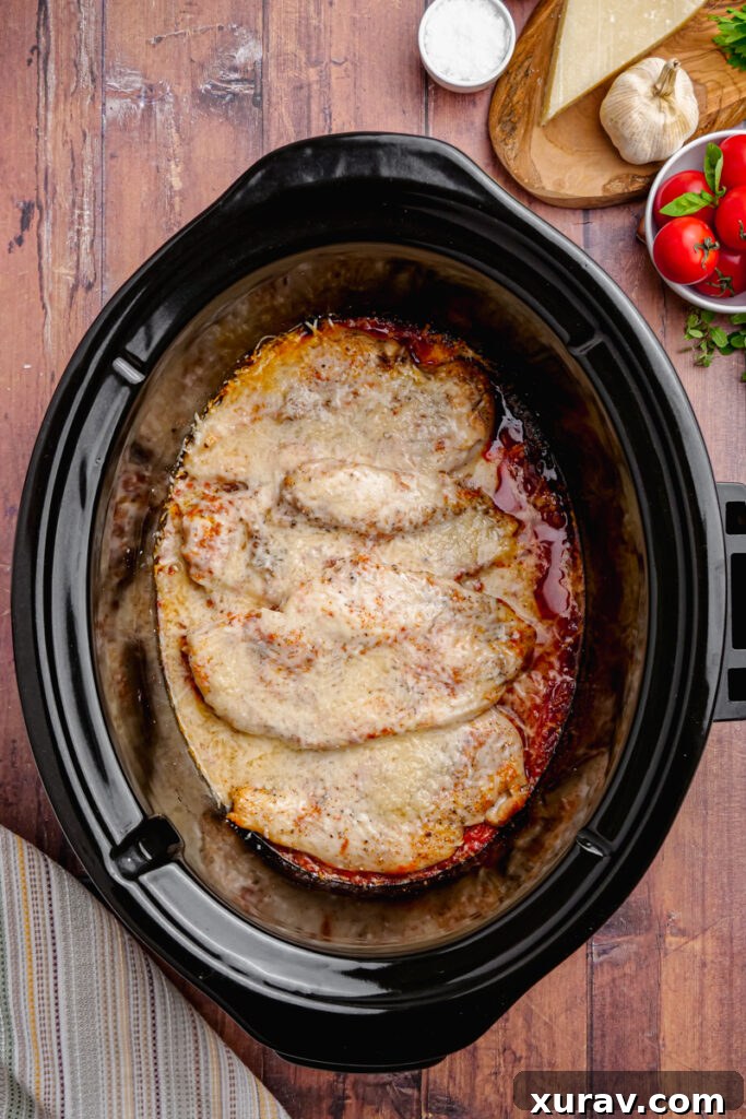 Close-up of Slow Cooker Chicken Pomodoro with melted Parmesan cheese on top, creating a golden, irresistible crust.