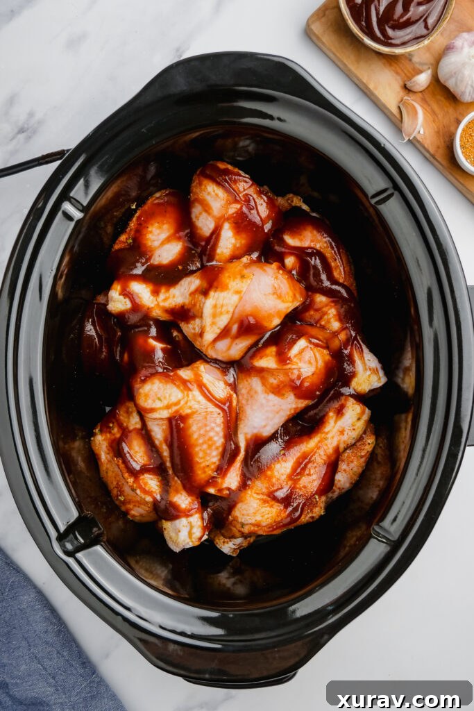 SLow Cooker BBQ Drumsticks in a slow cooker with sauce all over them.