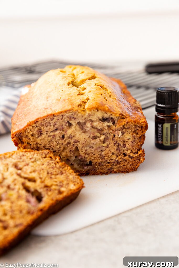 A loaf of banana bread that is sliced and doterra essential oil on the side. 
