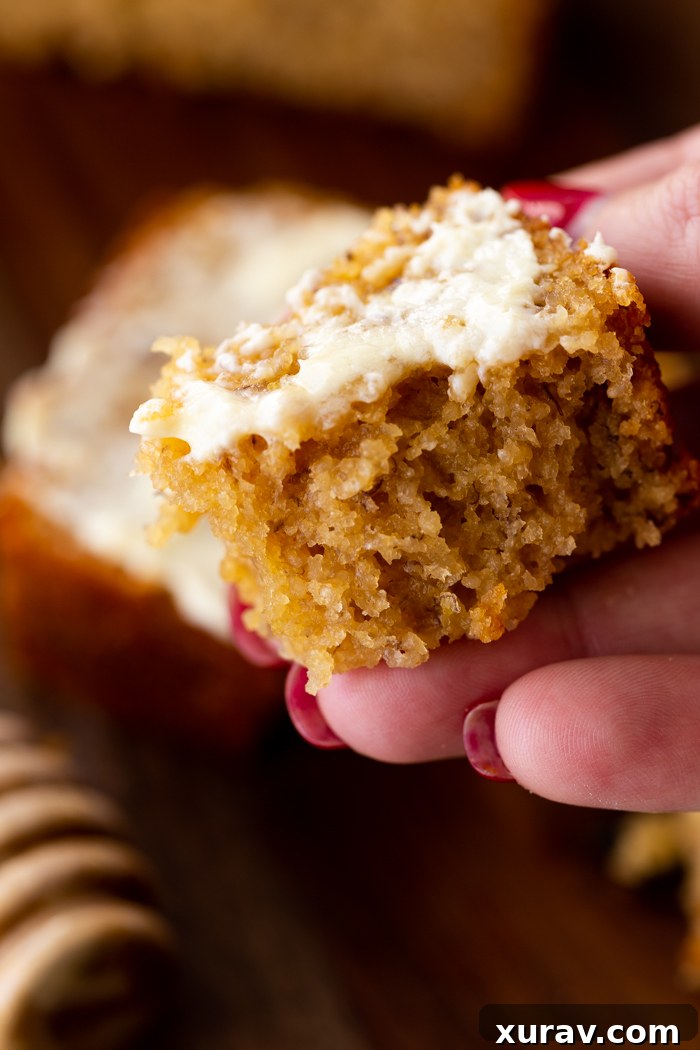 A close-up shot of a slice of Honey Whole Wheat Banana Bread, revealing its moist texture and golden crumbs.