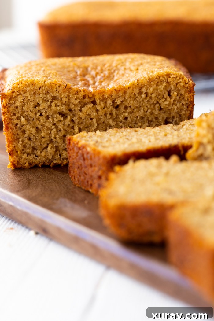 Two slices of Honey Whole Wheat Banana Bread on a white plate, ready to be served, with a blurred background.