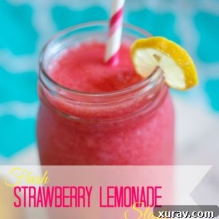 Close-up of a glass of Strawberry Lemonade Slush, garnished with fresh fruit