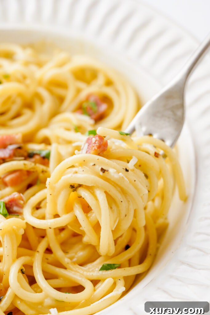 A fantastic plate of creamy spaghetti carbonara, garnished with fresh herbs and a fork, ready to be enjoyed.