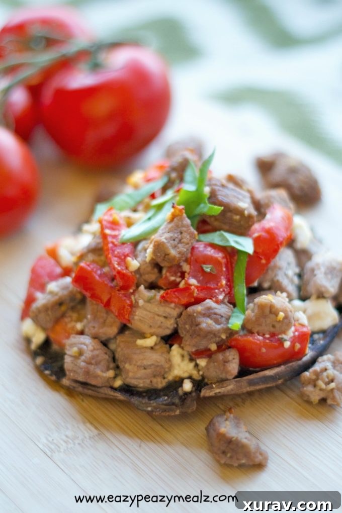 Close-up of a cooked steak stuffed portobello mushroom, highlighting the golden-brown steak and melted feta