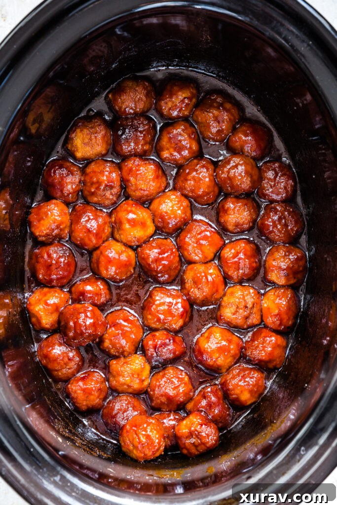 Sticky Sweet Slow Cooker Meatballs 4 A bowl of finished crockpot grape jelly meatballs ready for serving, with toothpicks.