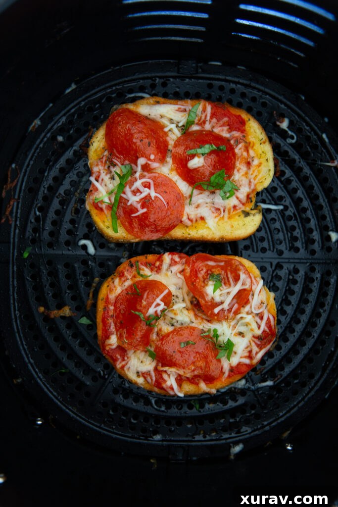 Air fryer pizza after it has been cooked and garnished with fresh basil. 