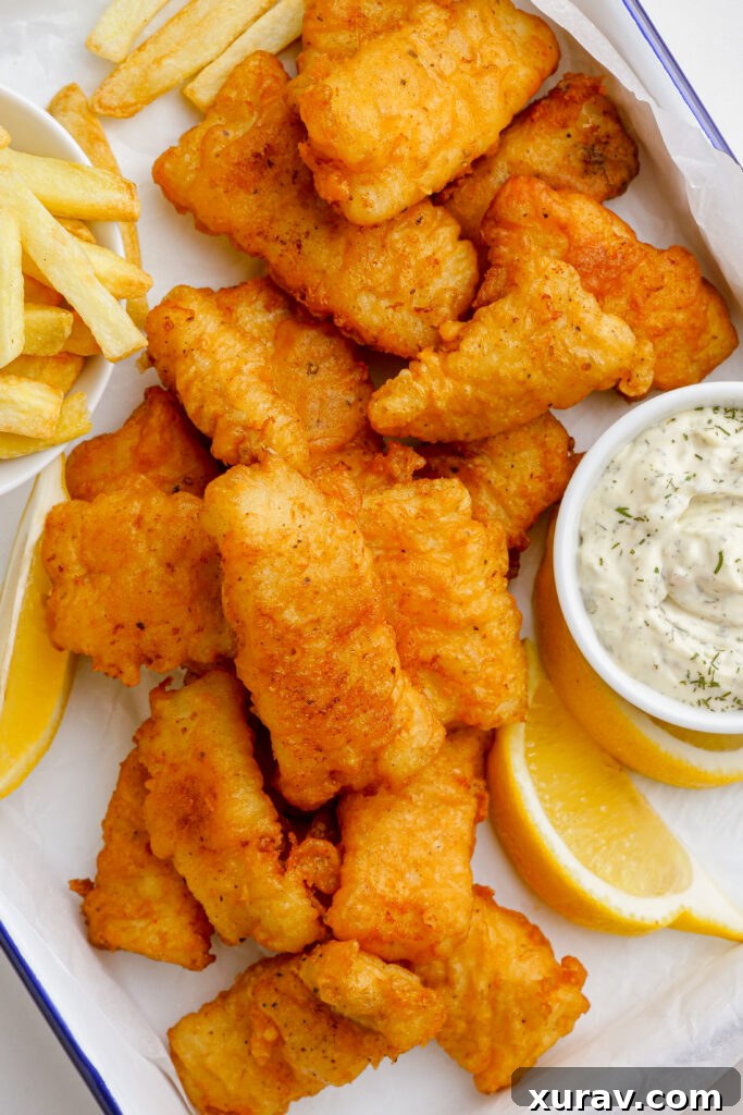 Platter of crispy beer battered fish with fries and tartar sauce