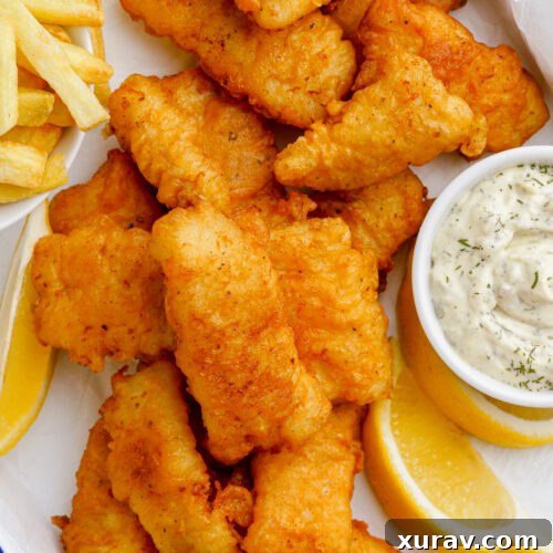 Crispy Beer Battered Fish Recipe, a bunch of fish on a platter with fries and tartar sauce