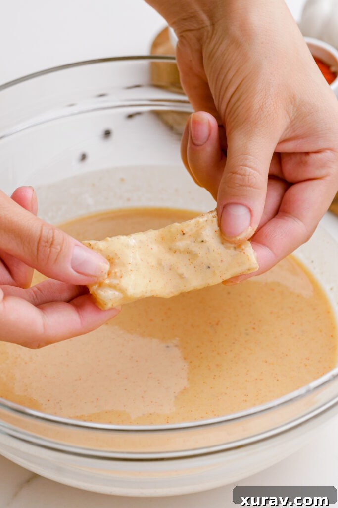 Dipping fish fillets into the beer batter