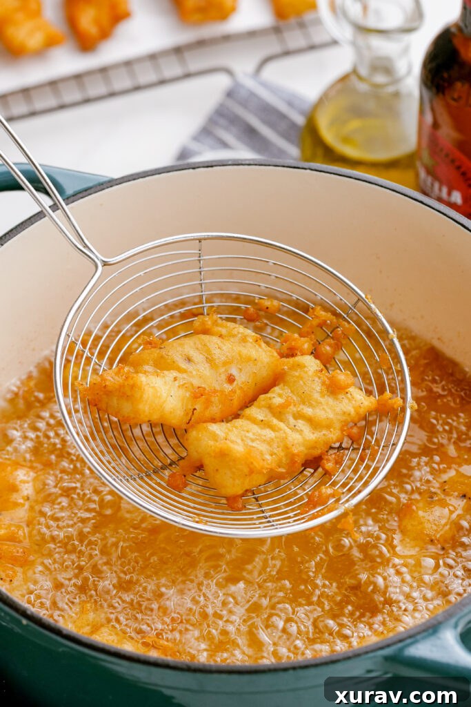 Frying beer battered fish in a Dutch oven until golden brown