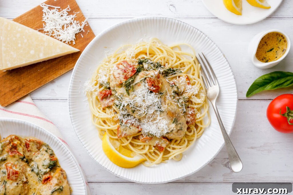 A plate of instant pot tuscan chicken over pasta with parmesan on top