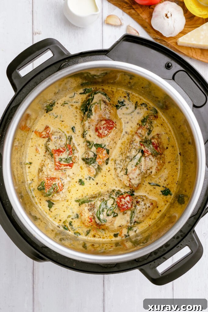 Adding the chicken back into the sauce to cook it for Tuscan Chicken made in the instant pot