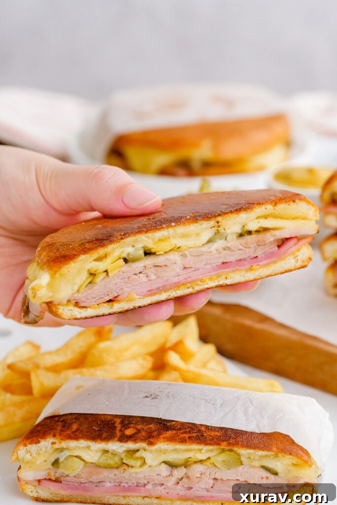 A close-up of the delicious layers within a sliced Cuban sandwich.